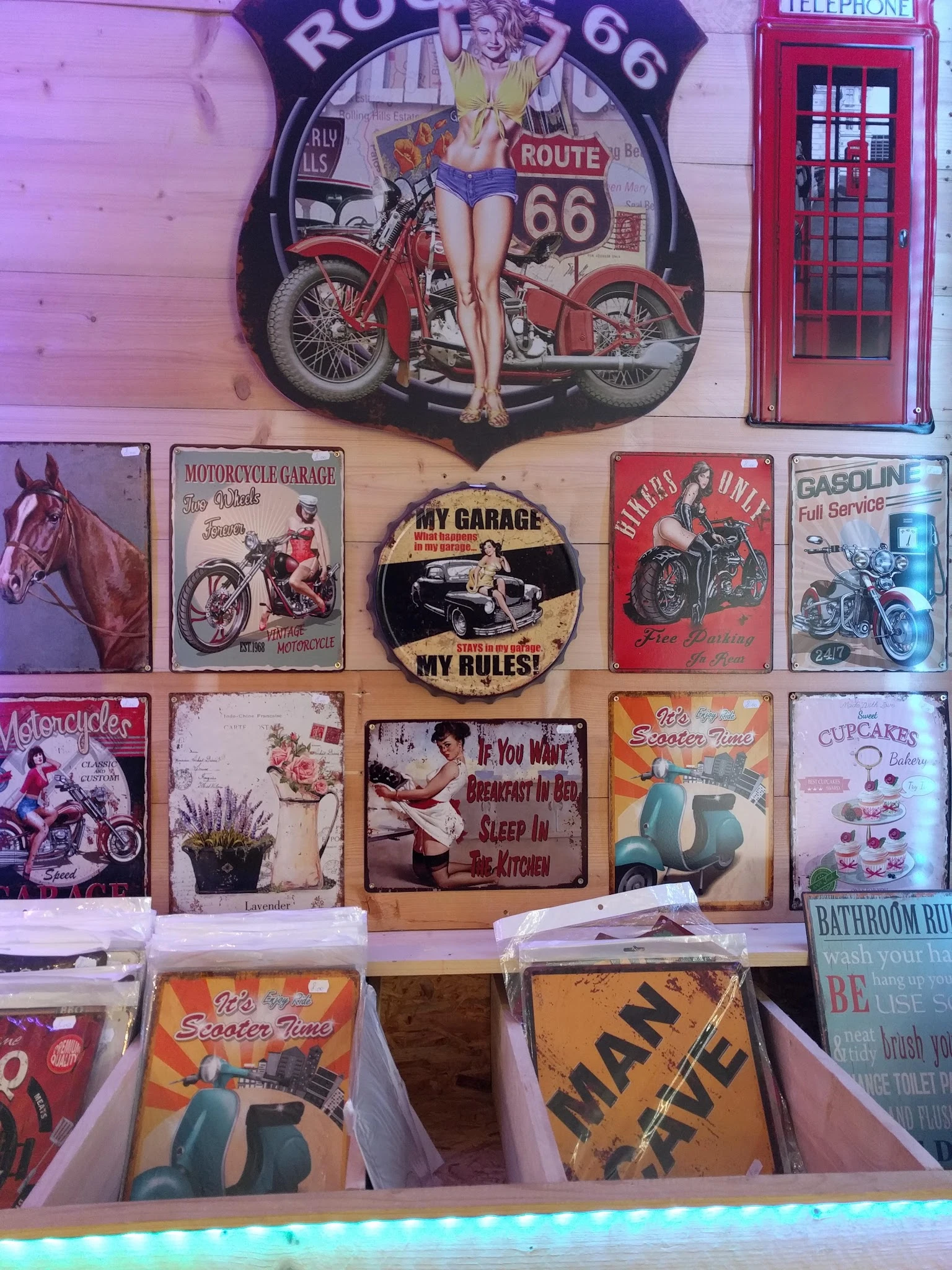 Muur met vintage decoratieve borden en blikken met motorfietsen, pinup-thema's en retro doodskisten