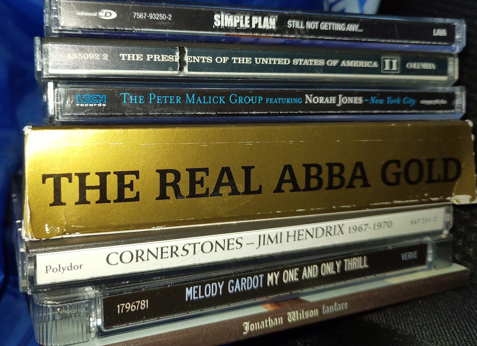 Stapel cd's en dvd's met artiesten zoals Simple Plan, ABBA en Jimi Hendrix