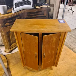 Houten kastje met twee deuren en plankjes, gemaakt van licht hout met warme toon
