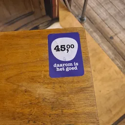 Prijssticker op houten meubel met tekst '45,00' en 'daarom is het goed'