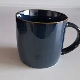 Donkerblauwe mok met gouden rand, close-up van een servies artikel
