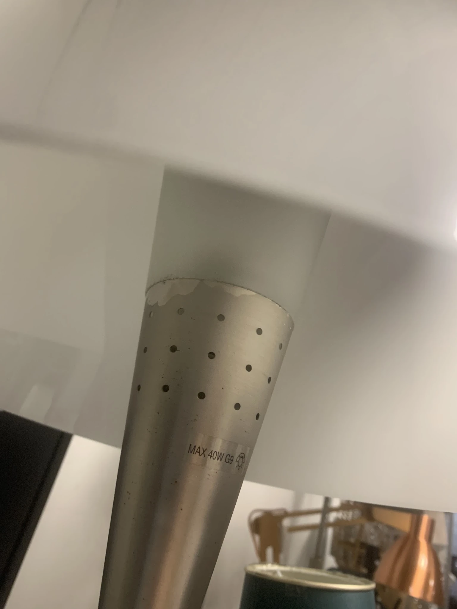 Close-up van een witte cilindervormige ventilatiebuis met gaten en tekstprint