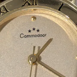 Close-up van een Commodoor klok met drie sterren en gouden wijzers op een glitterende wijzerplaat