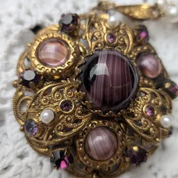 Goudkleurige broche met paarse amethist en andere halfedelstenen in sieraden-sieraad stijl