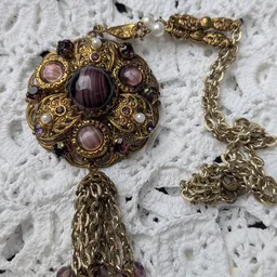 Goudkleurige vintage halsketting met paarse amethist stenen en parels op witte achtergrond