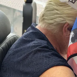 Persoon zittend in een voertuig, gedeeltelijk zichtbaar van achteren