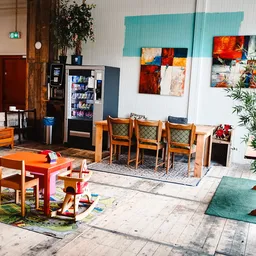 Winkelinterieur met houten meubels, kunstwerken aan de muur, speelgoed en plantenbakken
