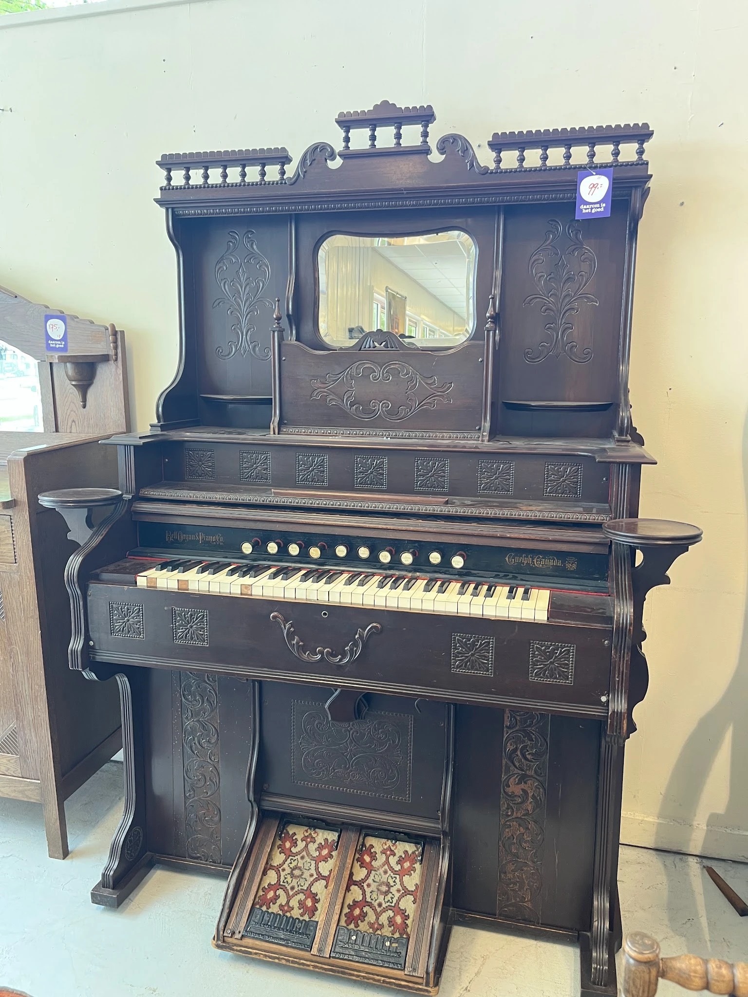 Antieke zwarte piano met decoratief snijwerk en een spiegel op het bovenwerk