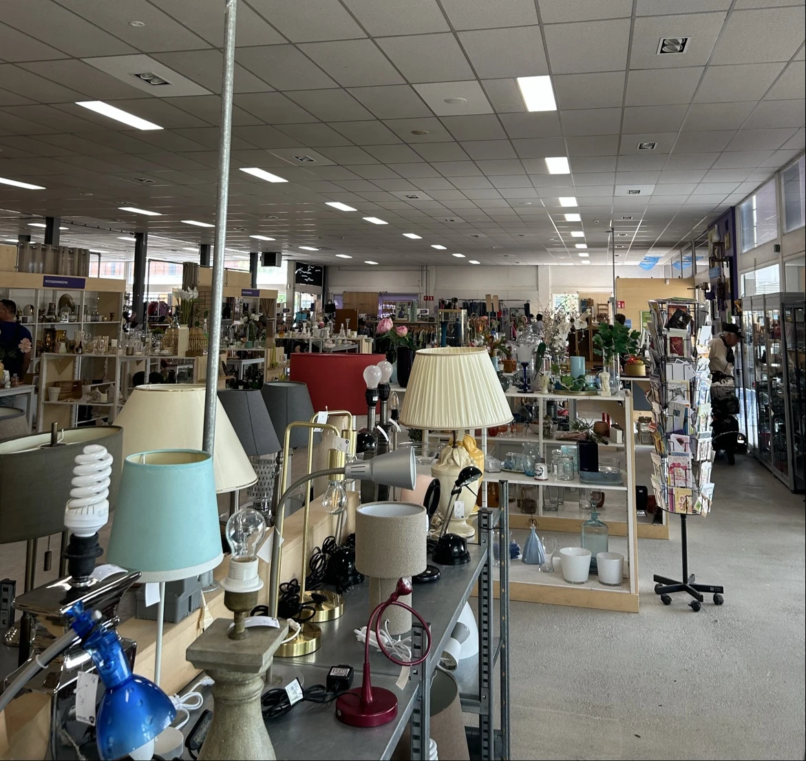 Overzicht winkelvloer met tafels met lampen, servies, decoratie en andere huishoudelijke artikelen