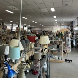 Overzicht winkelvloer met tafels met lampen, servies, decoratie en andere huishoudelijke artikelen