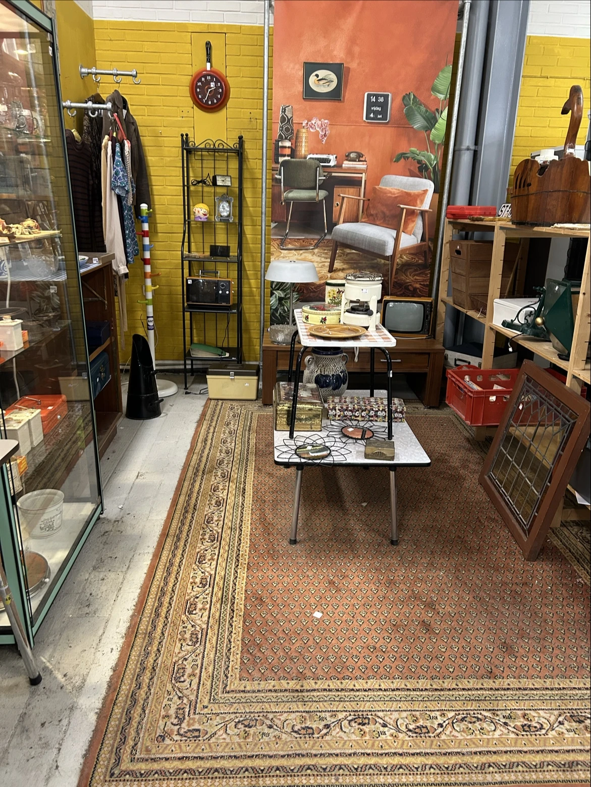 Winkelvloer met meubels, vintage artikelen en verschillende displaykasten in een kringloopwinkel