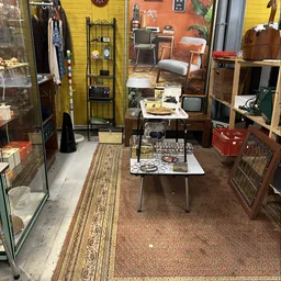 Winkelvloer met meubels, vintage artikelen en verschillende displaykasten in een kringloopwinkel