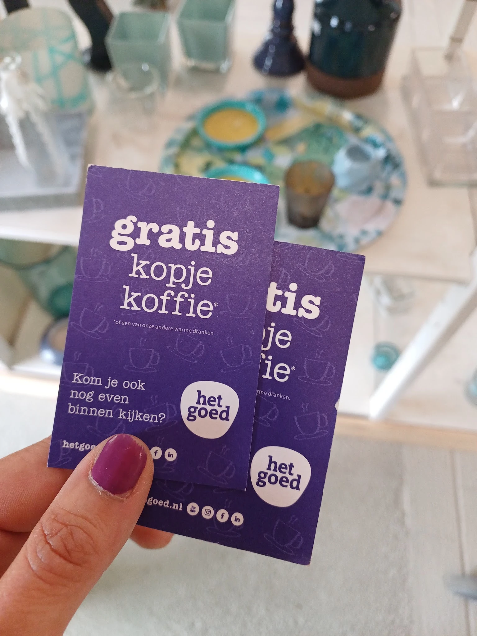 Paarse promotiefolder voor gratis kopje koffie van Het Goed kringloopwinkel
