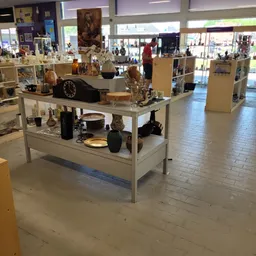 Uitstallingskasten met decoratieve artikelen, vazen, klokken en huishoudelijke spullen in een kringloopwinkel