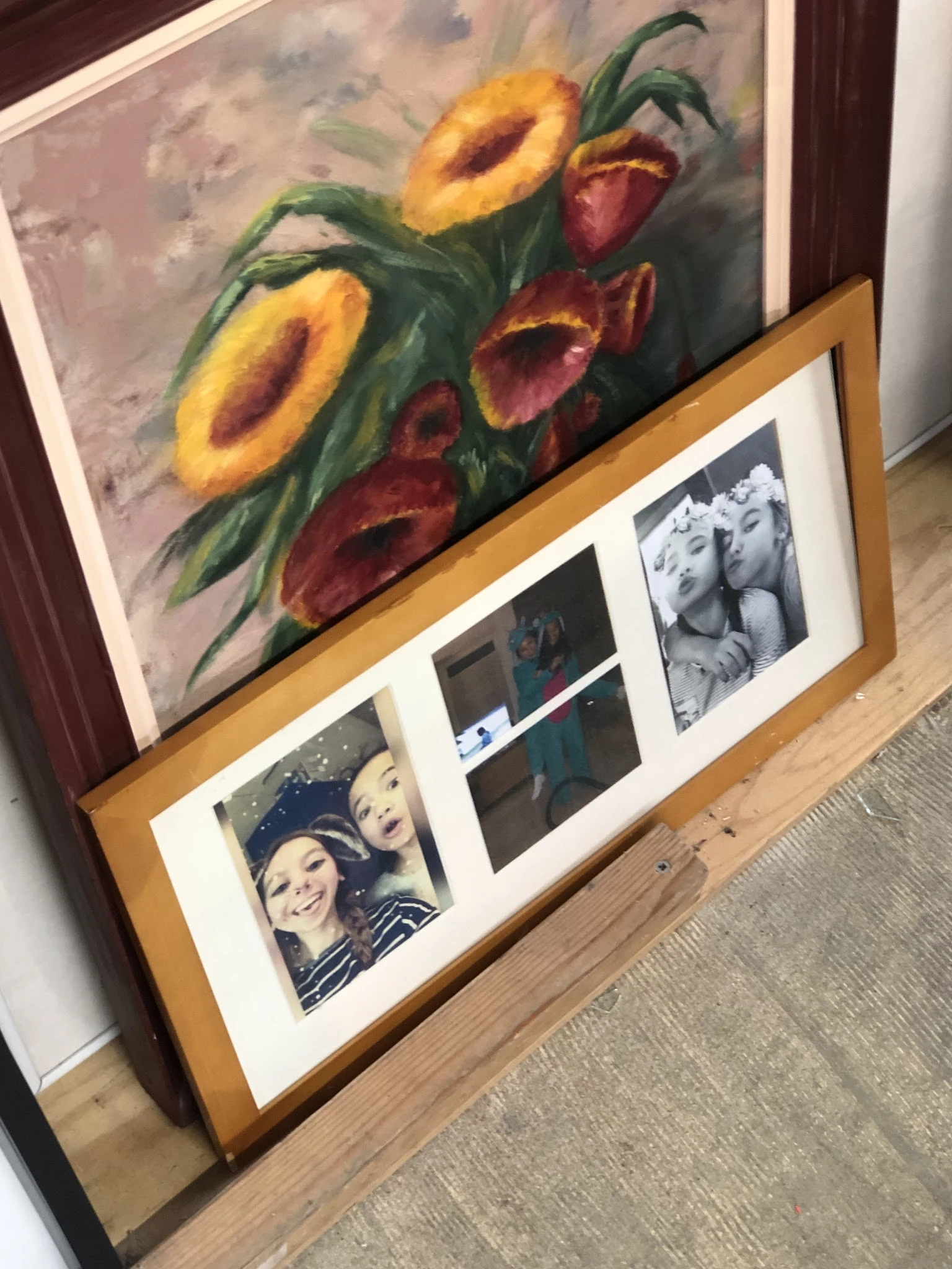 Wanddecoratie met schilderij van bloemen en fotolijst met zwart-witfoto's op houten frame