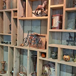 Houten stellingkast met tweedehands spullen: fiets, servies, lampen, boeken en decoratieartikelen