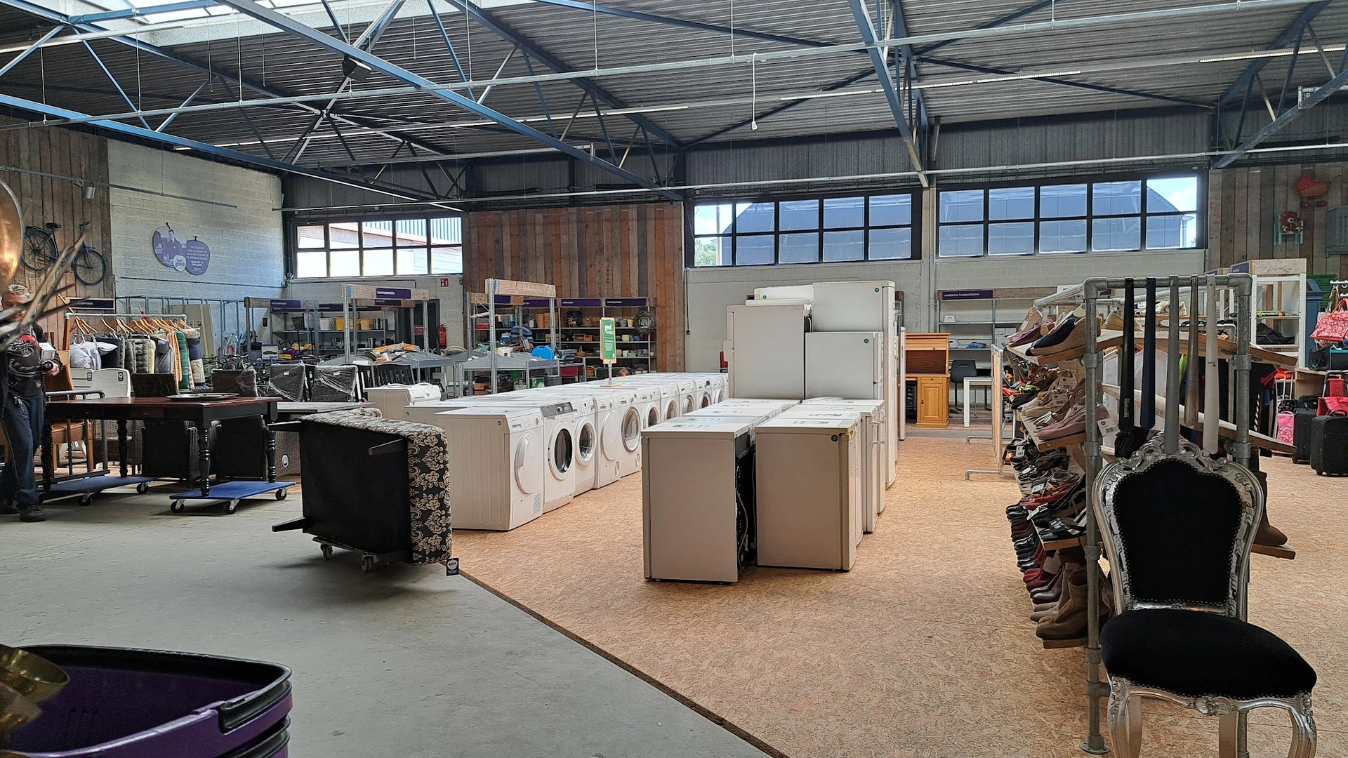 Wasmachines en droogkasten in een rij in de winkelhal van een kringloopwinkel