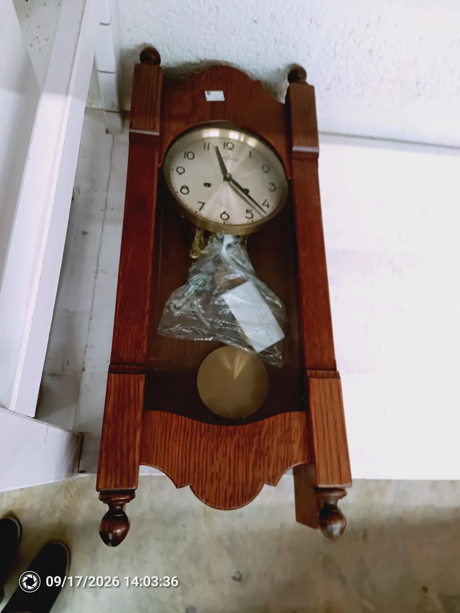 Houten wandklok met slingerwerk en koperen slinger, nog in verpakking