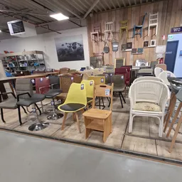 Winkelvloer met diverse meubels en inrichting, waaronder stoelen, tafels en kasten op uitgestalde oppervlakte