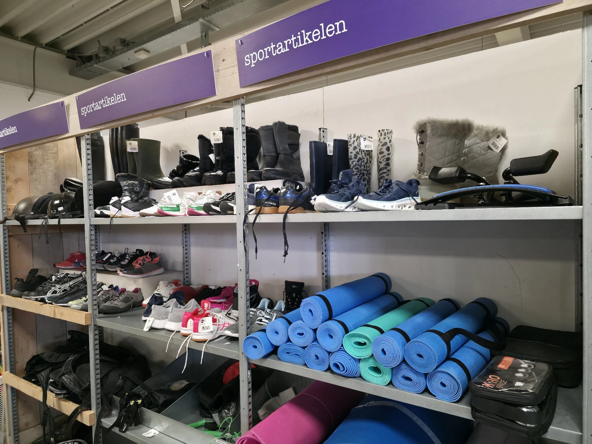 Stellingen met sportartikelen: yoga- en fitnessmaterialen, schoenen, kleding en sportuitrusting