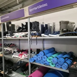 Stellingen met sportartikelen: yoga- en fitnessmaterialen, schoenen, kleding en sportuitrusting