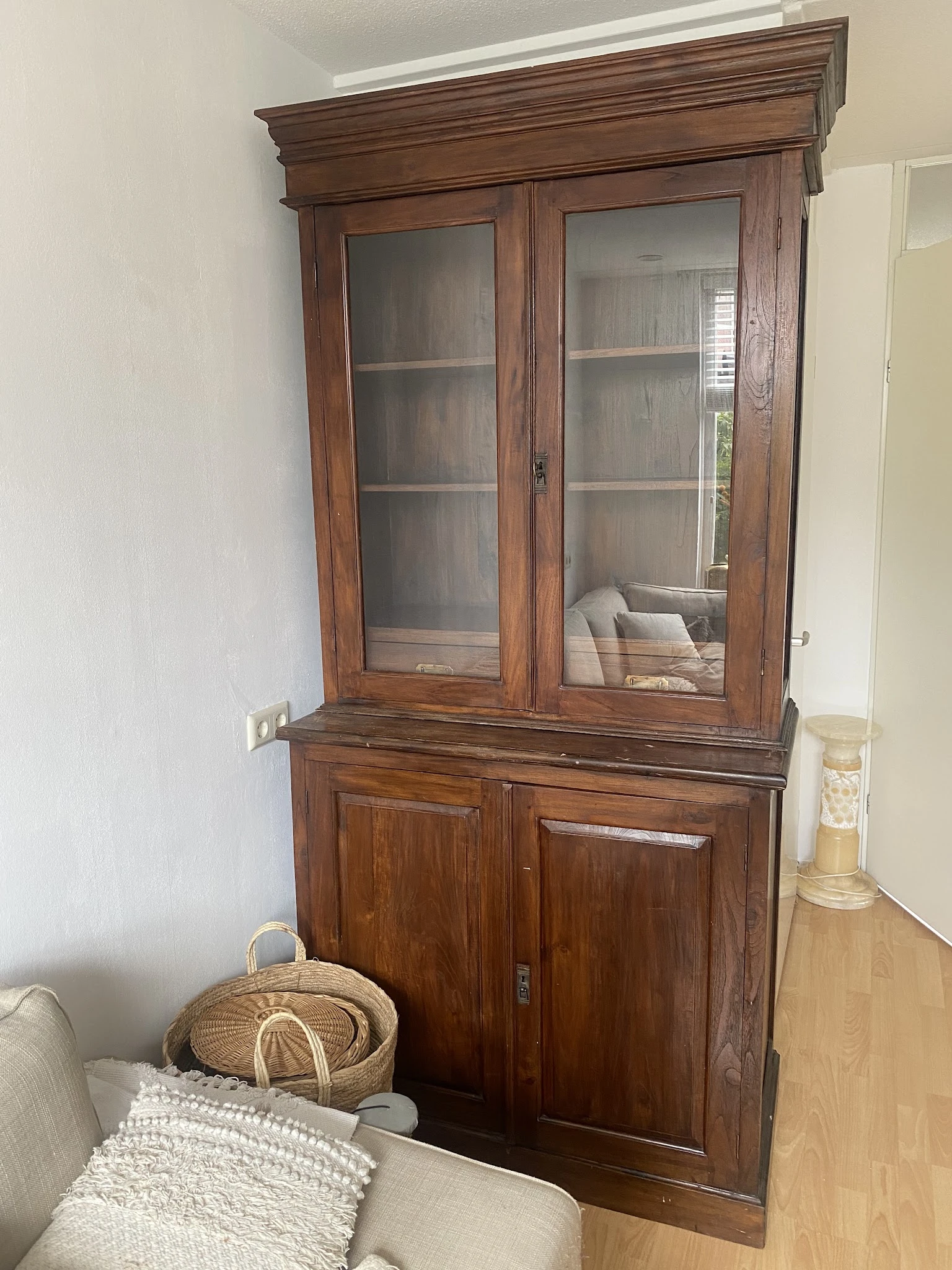 Houten glazen vitrinekast met twee deuren en onderkasten, gevuld met boeken