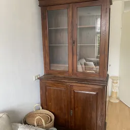 Houten glazen vitrinekast met twee deuren en onderkasten, gevuld met boeken
