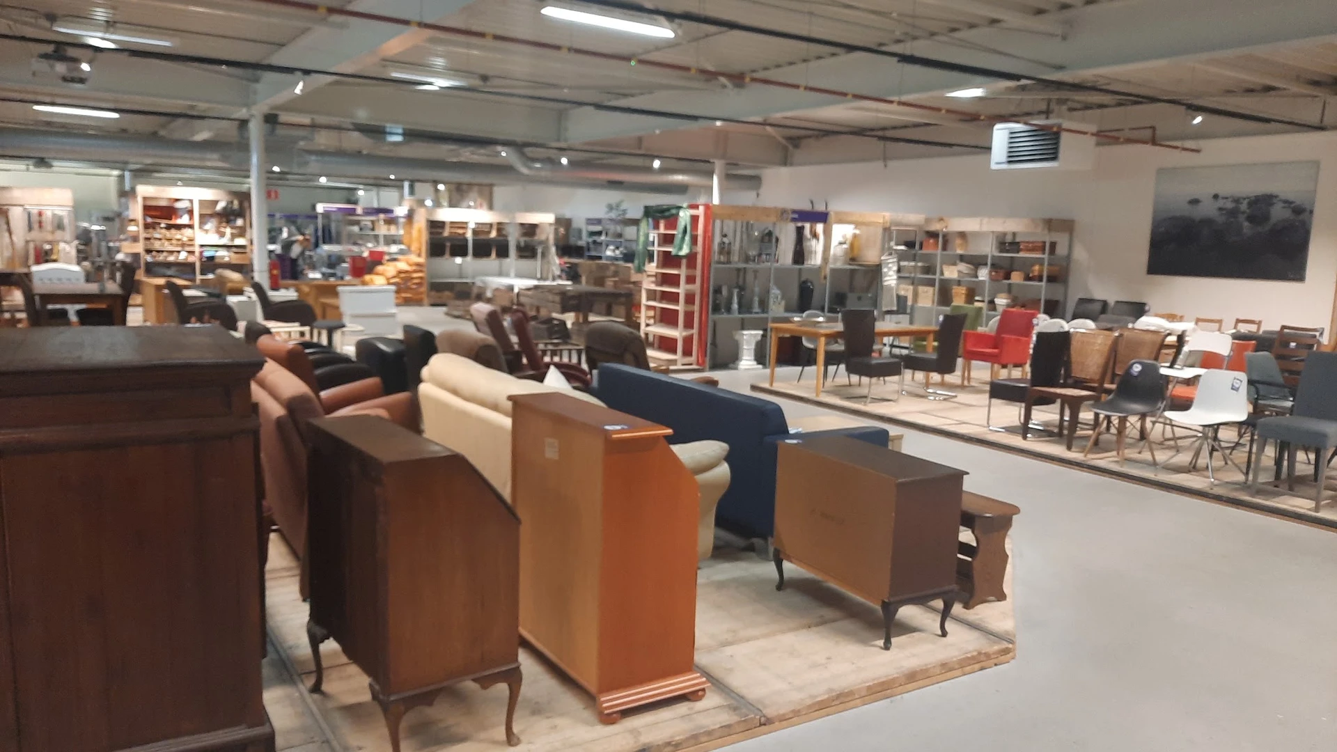 Winkelvloer met diverse meubels uitgestald, waaronder bruine en crème gekleurde fauteuils, kasten en andere meubelstukken in 