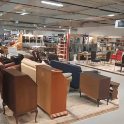 Winkelvloer met diverse meubels uitgestald, waaronder bruine en crème gekleurde fauteuils, kasten en andere meubelstukken in 