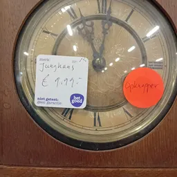 Wandklok met Junghans-merk en prijssticker van €9,99
