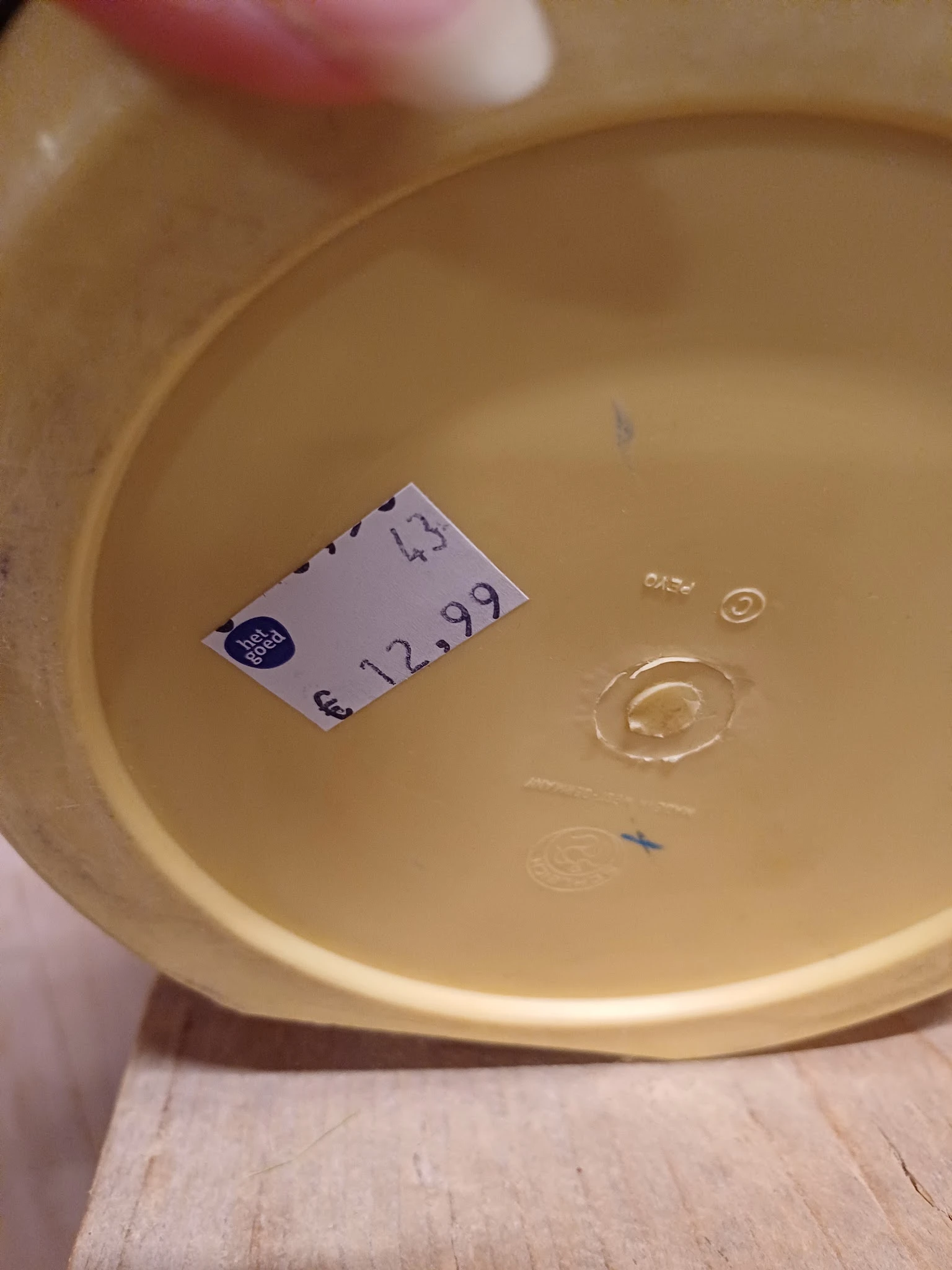 Geel/crèmekleurig serviesgoed met prijskaartje €12,99 in een schaal