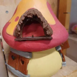 Close-up van een speelgoedhuisje met roze dak en bruine deur, onderdeel van kinderspeelgoed