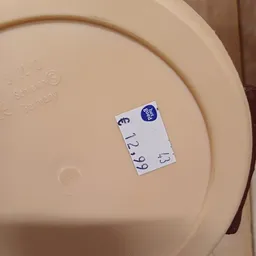 Prijssticker met blauw logo op beige oppervlak