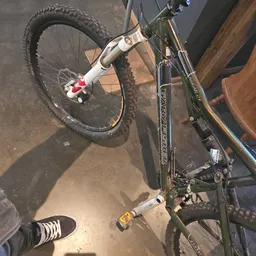 Tweedehands mountainbike met witte vork en zwart frame, van bovenaf gefotografeerd