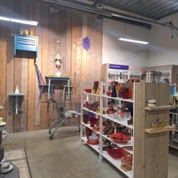 Winkelvloer met stellingen vol huishoudartikelen, decoratie en serviesgoed in een kringloopwinkel