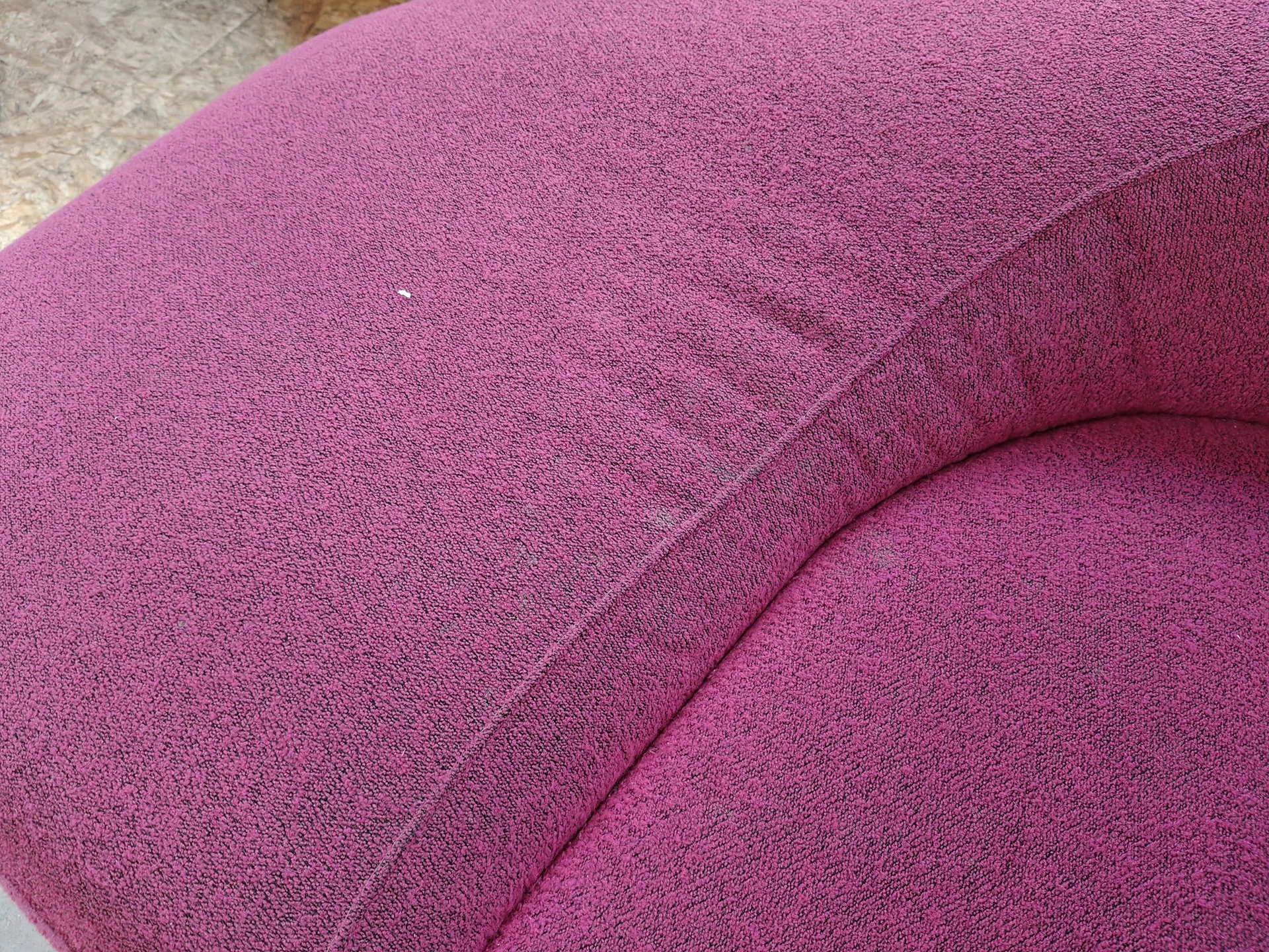 Close-up van een roze geweven fauteuil of stoel met zichtbare textuur en naden