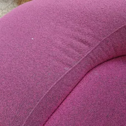 Close-up van een roze geweven fauteuil of stoel met zichtbare textuur en naden