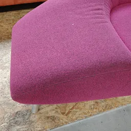 Roze/paarse stofkussen of poef op metalen poten, gedeeltelijk op kurk- en betonvloer