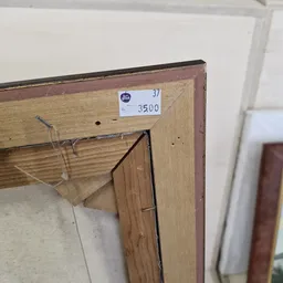 Prijskaartje met nummer 37 en prijs 3500 op houten meubelstuk in kringloopwinkel