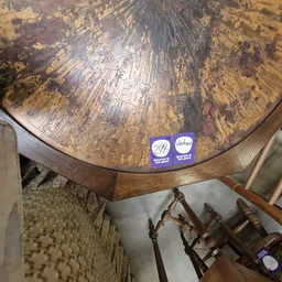 Bovenaanzicht van een houten globe met wereldkaart en twee blauwe fabrikantsstickers