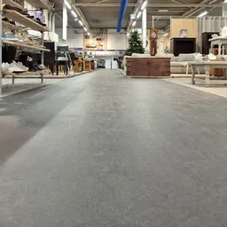 Ruime winkelvloer van een kringloopwinkel met meubels en huishoudartikelen aan beide zijden