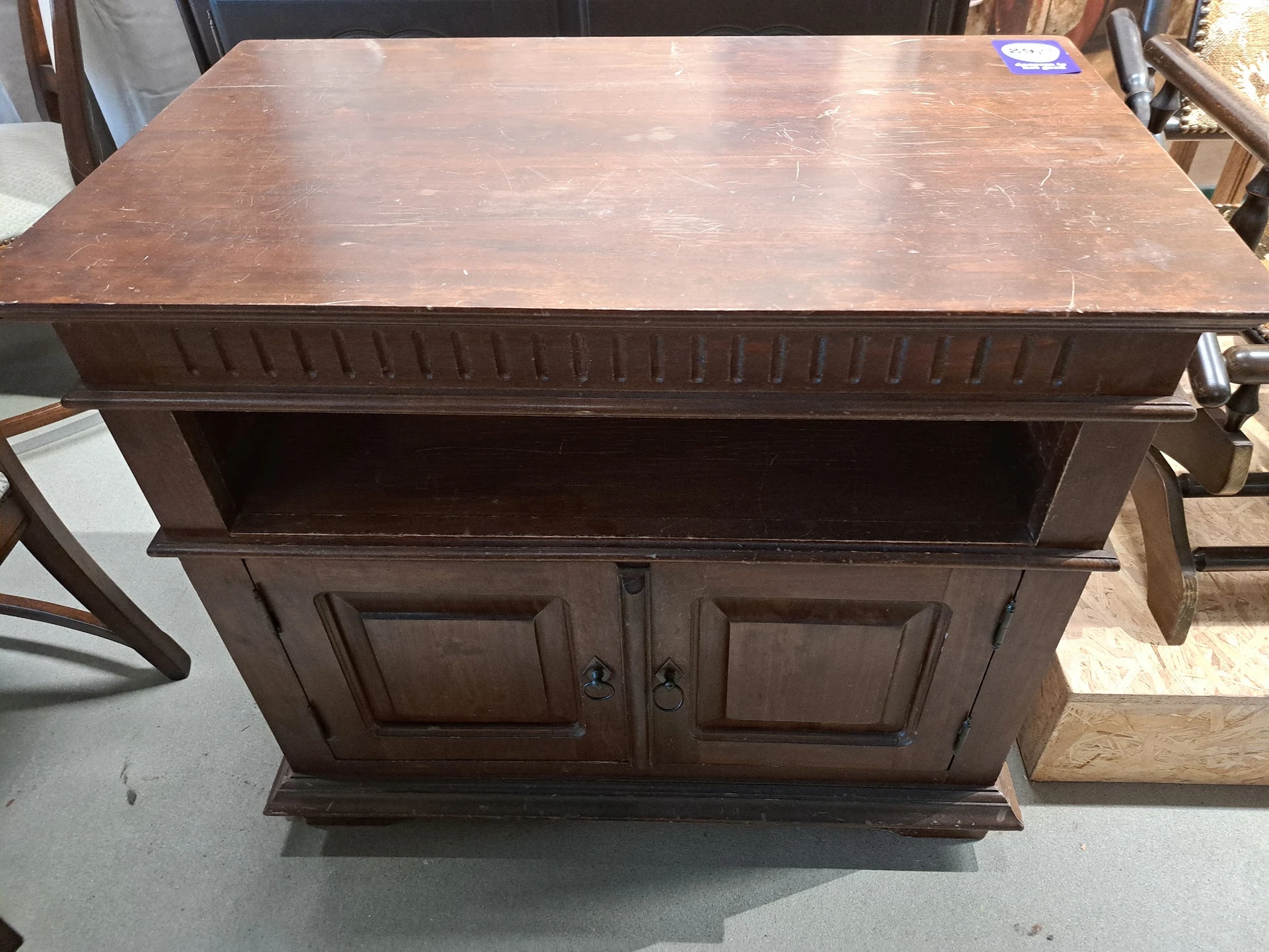 Donkerbruin houten dressoir met open legvak en twee deuren met panelen