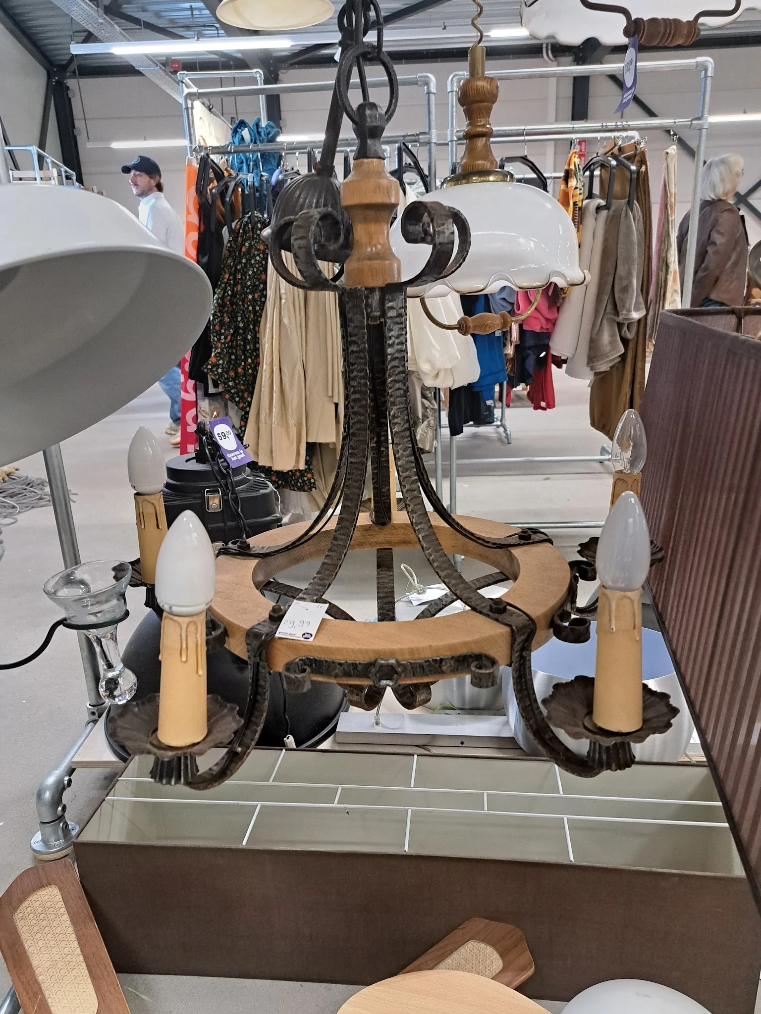 Vintage hanglamp met houten armen en zwarte details, uitgestald in de winkel