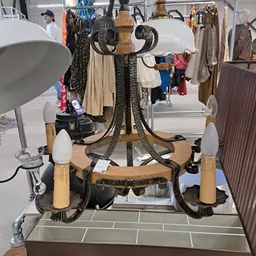 Vintage hanglamp met houten armen en zwarte details, uitgestald in de winkel
