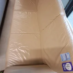 Close-up van een beige matras of matraskussen met plastic verpakking en etiket