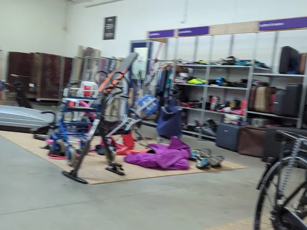 Winkelvloer met fietsen, stellingen met kleding en diverse spullen, onscherp beeld