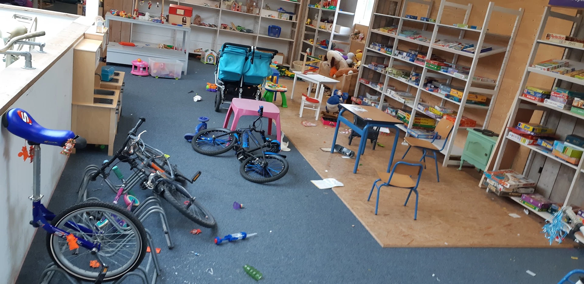 Winkelvloer met fietsen, kindervoertuigen, speelgoed en stellingen met diverse spullen