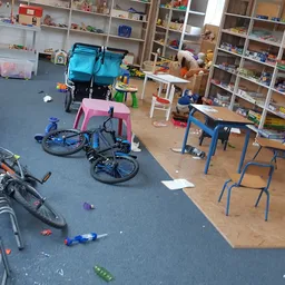 Winkelvloer met fietsen, kindervoertuigen, speelgoed en stellingen met diverse spullen