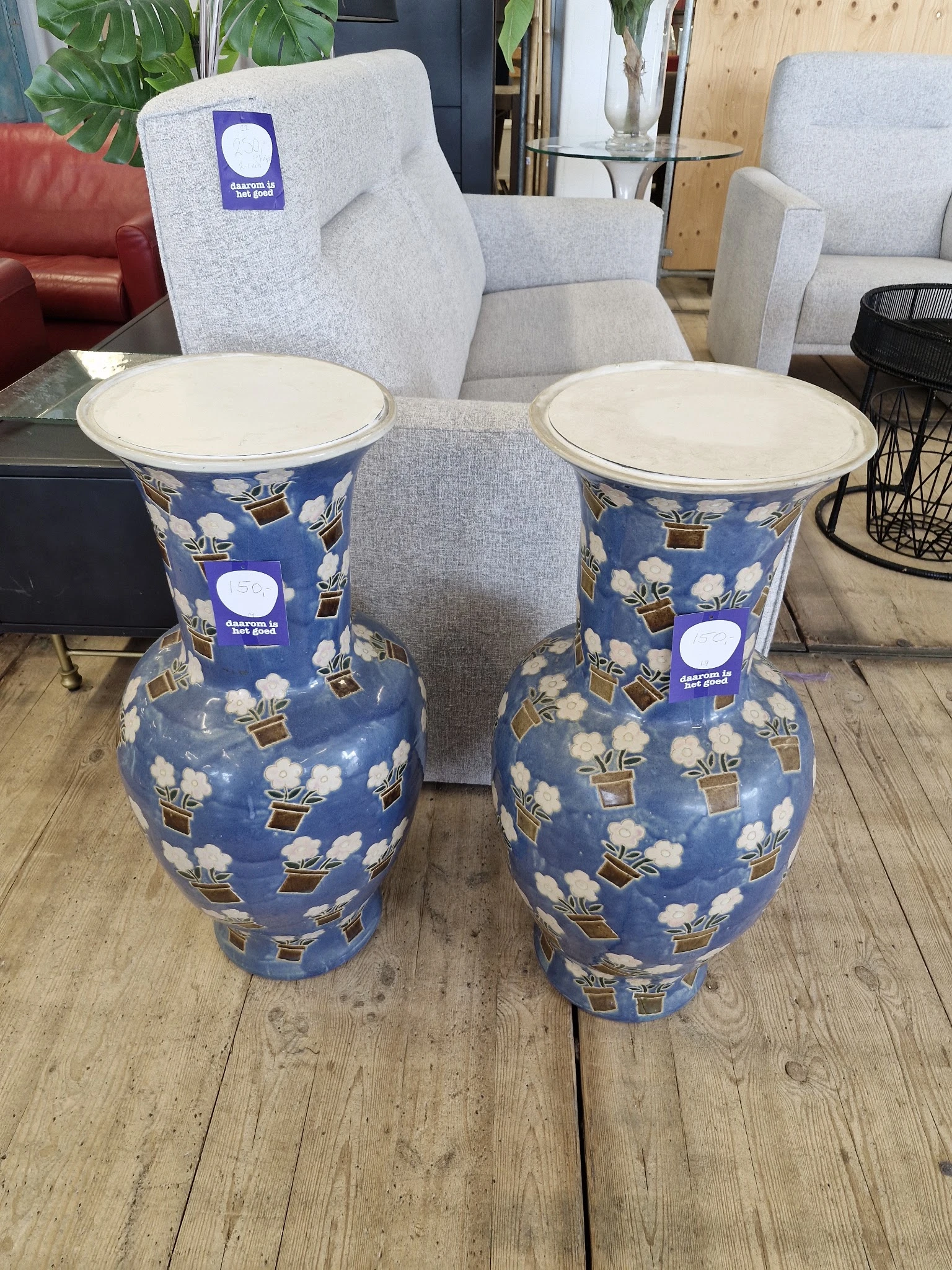 Twee blauwe decoratieve vazen met wit en goudkleurig bloempatroon en crèmekleurige randen
