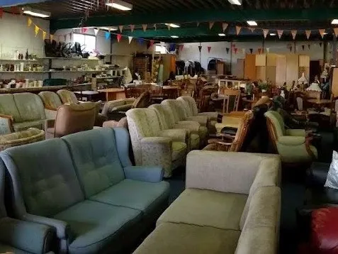 Winkelvloer met diverse tweedehands meubels, voornamelijk fauteuils en stoelen in verschillende kleuren en stijlen